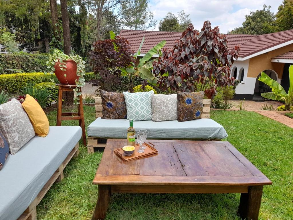 un jardín con 2 sofás y una mesa de centro en Utamaduni House B&B, en Arusha