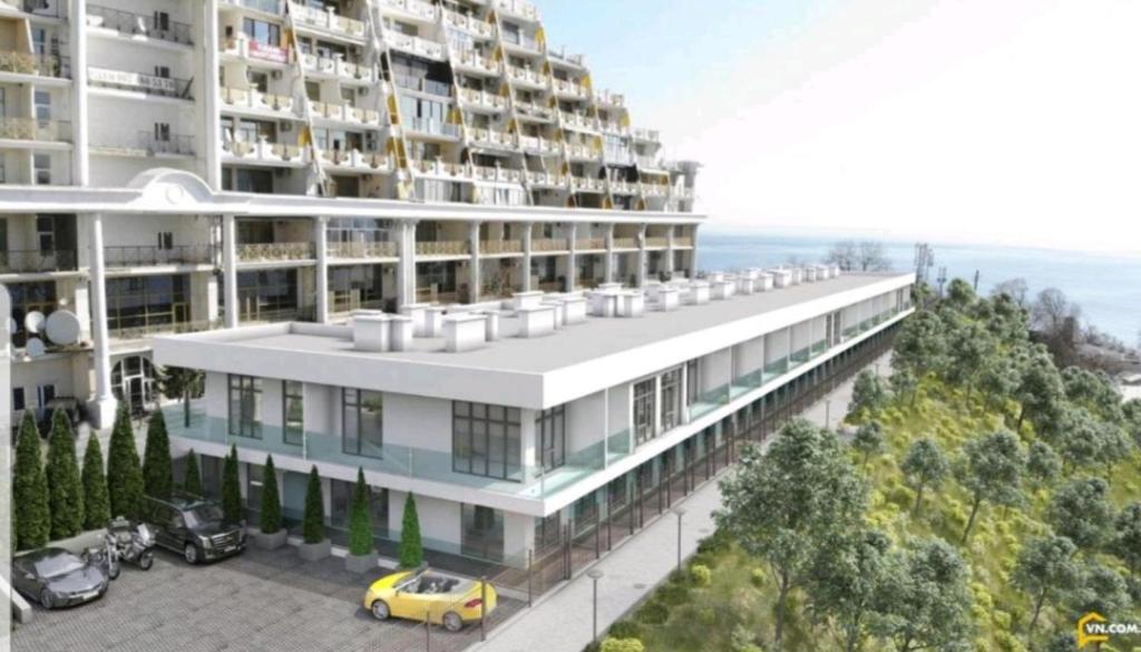 a building with a yellow car parked in front of it at Sunrise Arcadia Sky in Odesa