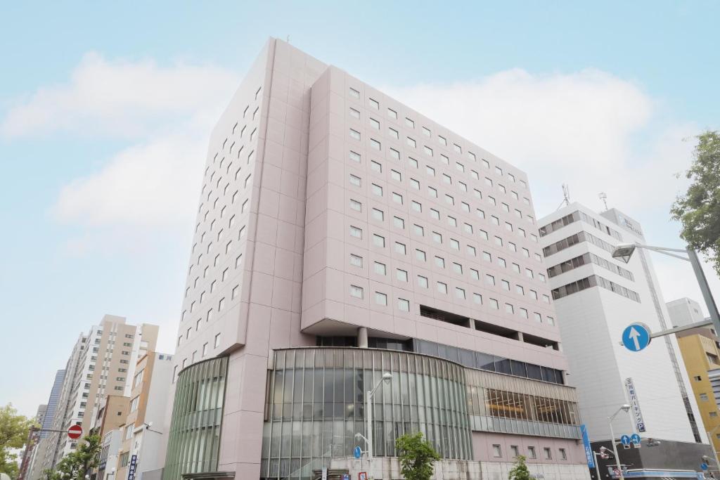 a tall white building in a city at Hiroshima Tokyu REI Hotel in Hiroshima