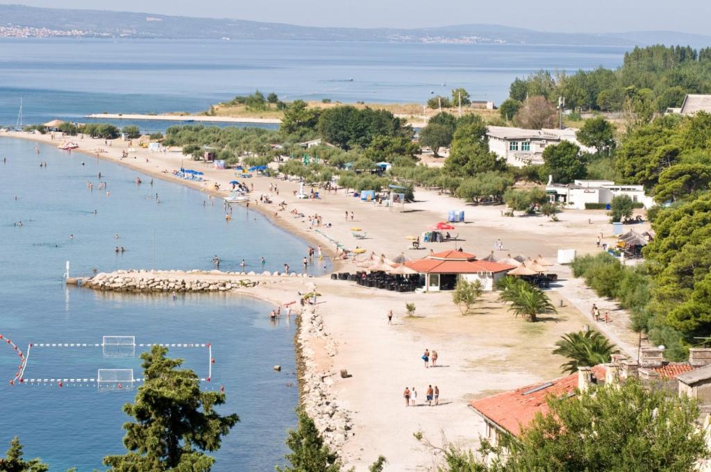 a beach with a group of people in the water at Apartment in Duce with sea view, terrace, air conditioning, Wi-Fi (4166-4) in Duće