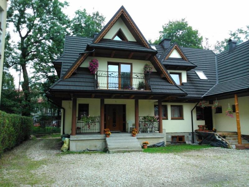 a house with a gambrel roof with a balcony at Villa Maja in Zakopane
