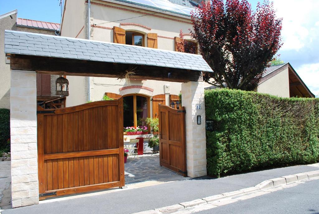 una casa con una puerta de madera y una valla en le jardin des quatres saisons, en Rilly-la-Montagne