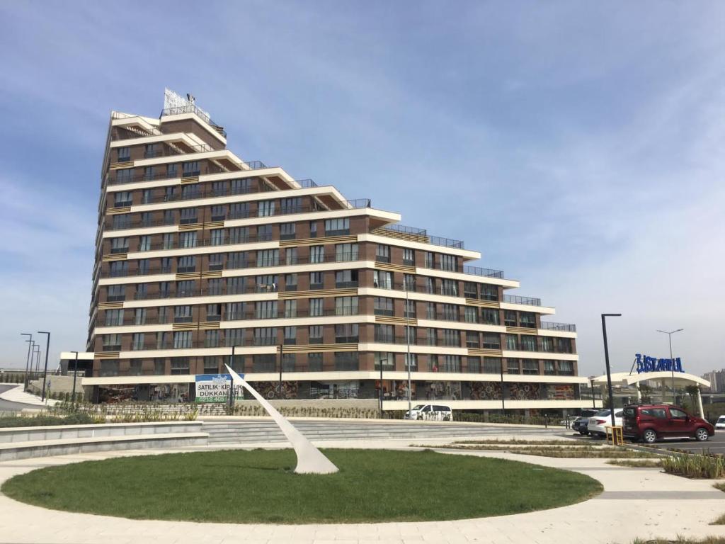 a large building with a sculpture in front of it at Garden Grandresidence in Basaksehir