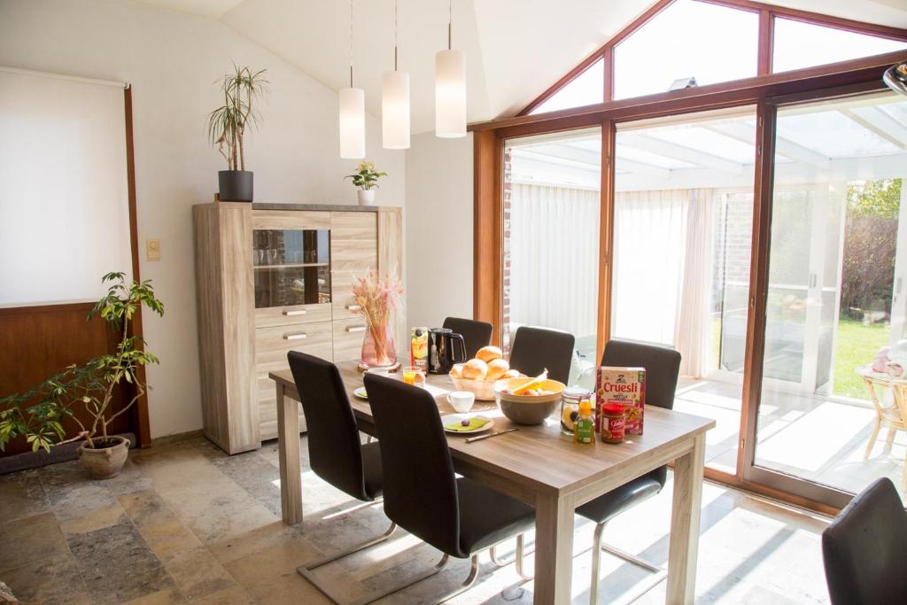ein Esszimmer mit einem Tisch und Stühlen in der Unterkunft Vakantiehuis Ooglée in Hooglede
