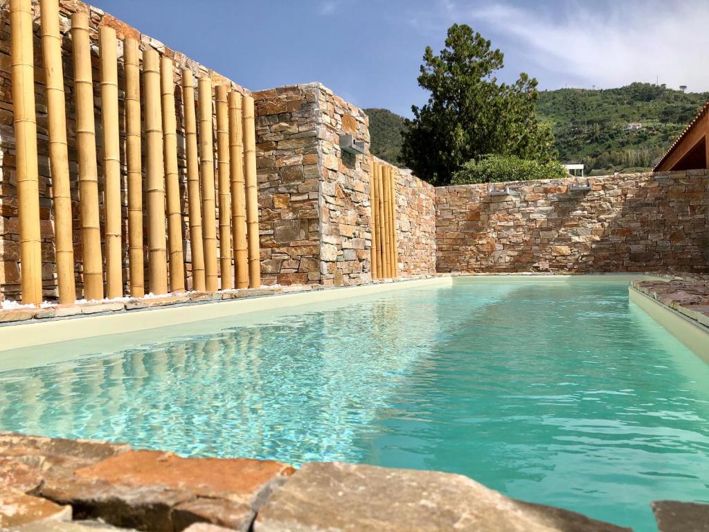 uma piscina em frente a uma parede de pedra em Villa Arcipelago em Cefalù