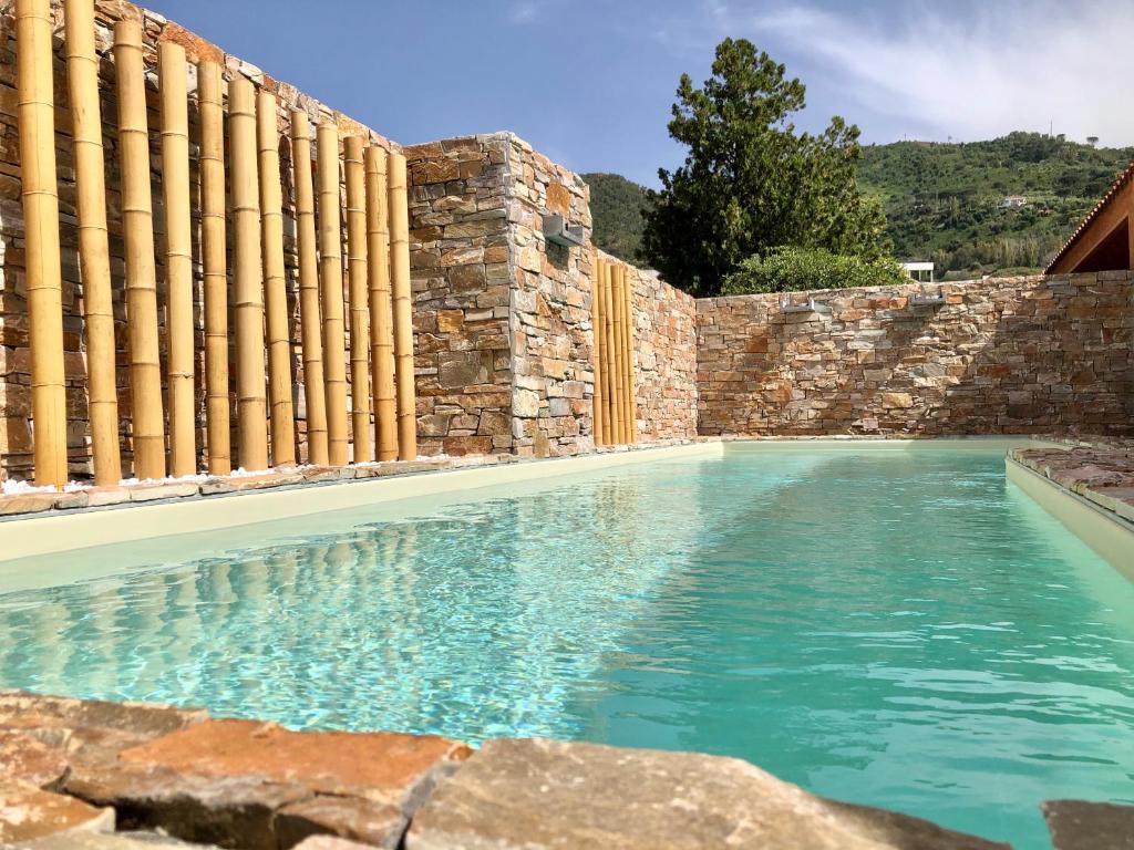 een zwembad voor een stenen muur bij Villa Arcipelago in Cefalù