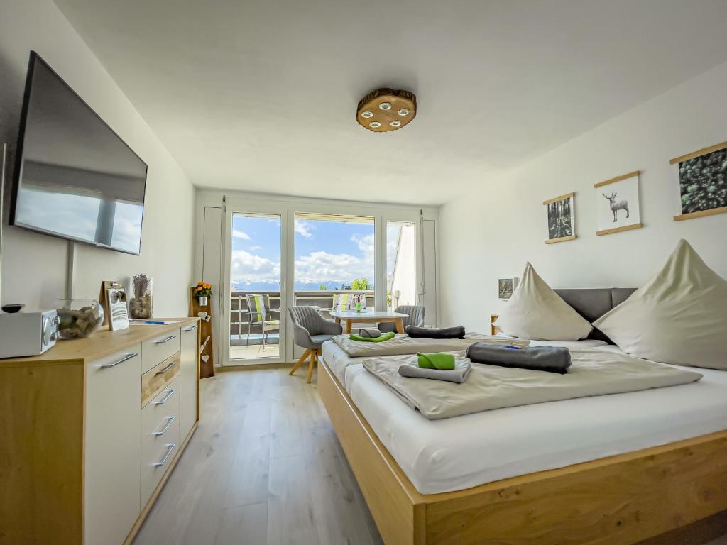 a bedroom with a large bed and a television at FeWo Längl -Alpenguck- mit Pool und Sauna im Allgäu in Scheidegg