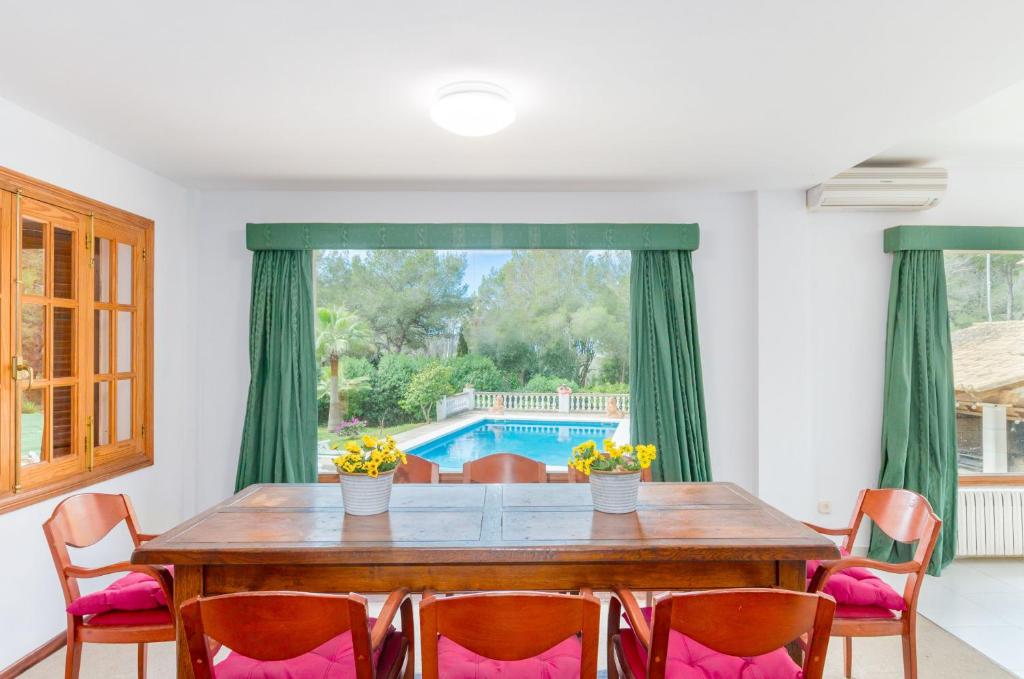 a dining room with a table and chairs and a pool at Your House Can Marques in Palma de Mallorca