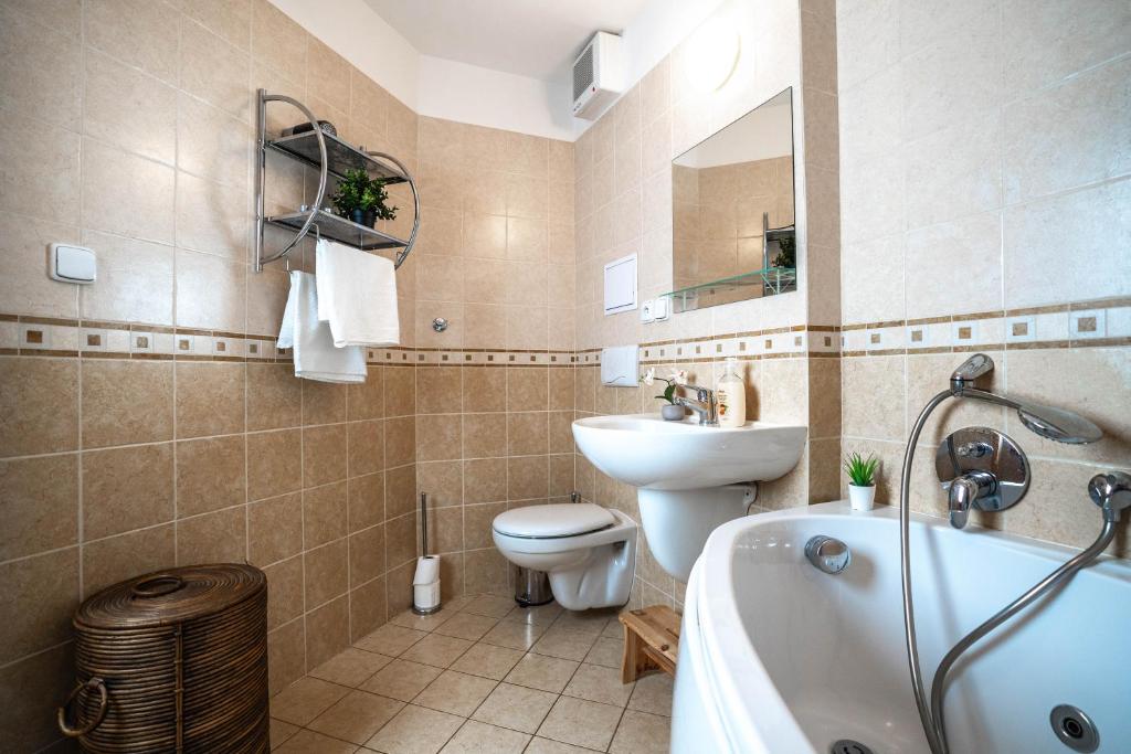 łazienka z wanną, toaletą i umywalką w obiekcie Apartmán Svatý Petr w Szpindlerowym Młynie