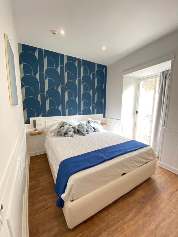 1 dormitorio con 1 cama y una pared azul y blanca en Hotel Europeo Napoli, en Nápoles