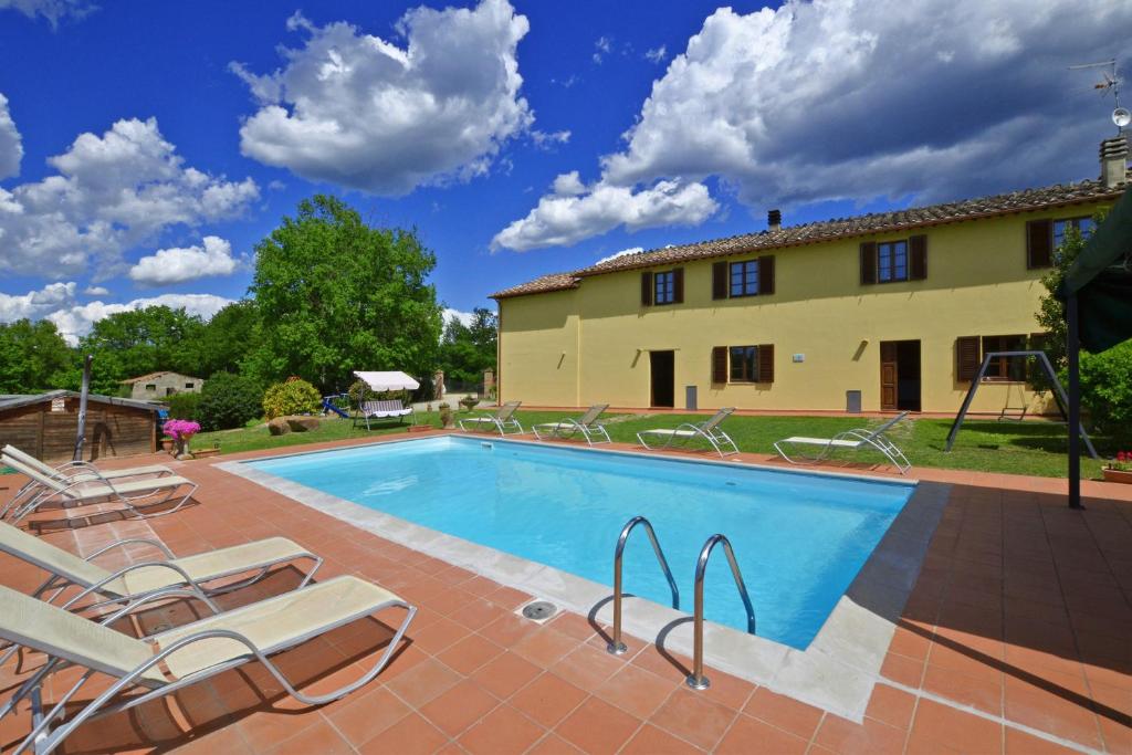 una piscina frente a una casa con tumbonas en Casa Sofi, en Monticiano