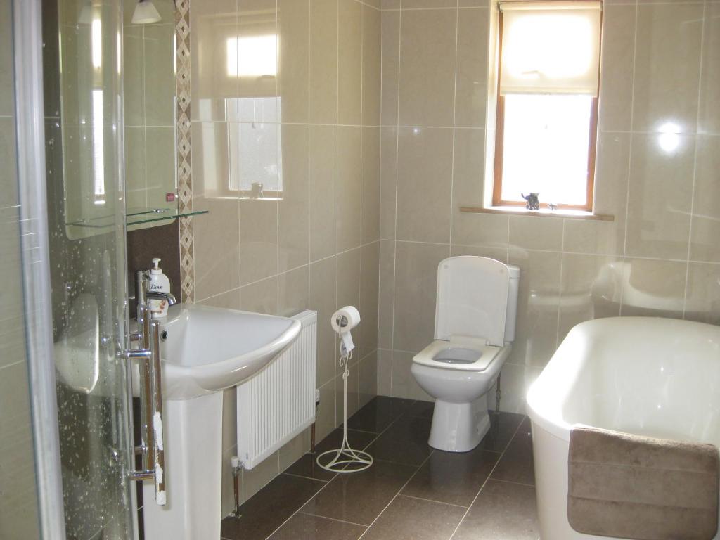 y baño con lavabo, aseo y bañera. en Broadhaven Bay View Private House, en Belmullet