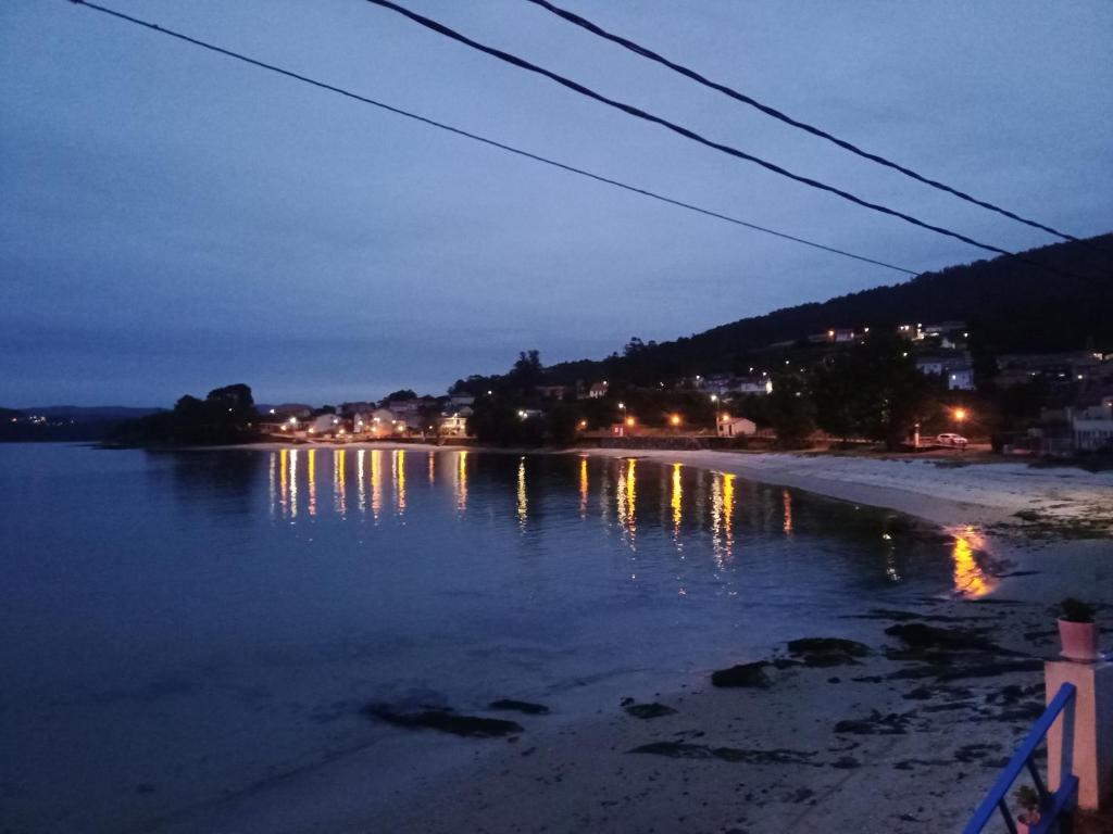 - une vue sur une étendue d'eau la nuit dans l'établissement Apartamento playa, à La Corogne