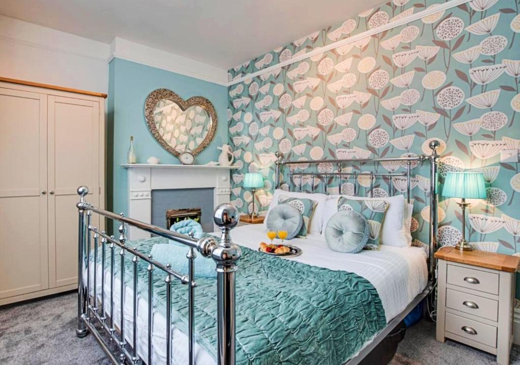 a bedroom with a bed with a heart patterned wall at Silverwood Apartment, Whitby in Whitby