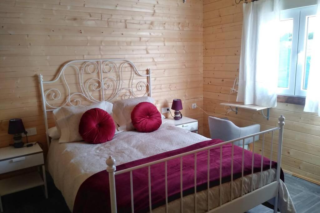 sypialnia z łóżkiem z 2 czerwonymi poduszkami w obiekcie Los Tréboles w mieście Bocigas