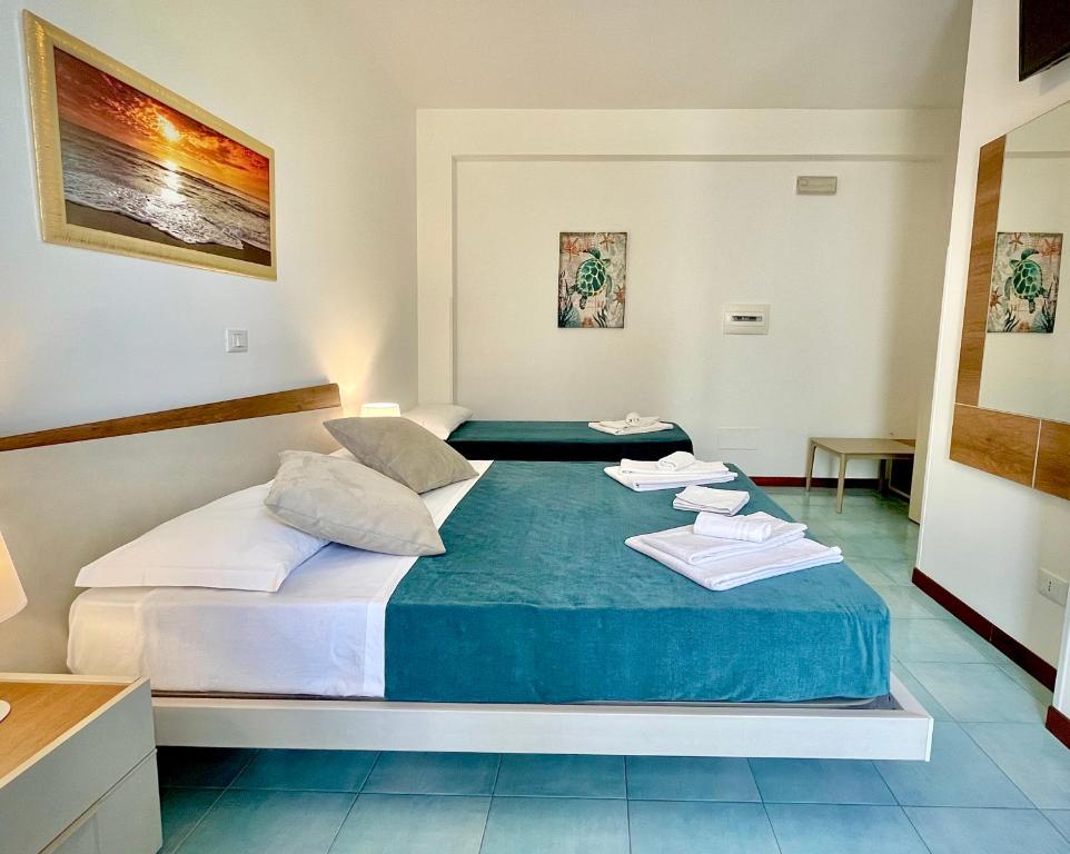 a bedroom with a bed with towels on it at Hotel Sikania in San Vito lo Capo