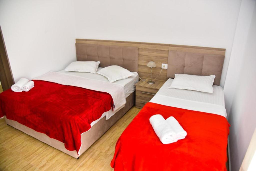 a bedroom with two beds and a red blanket at Vila Duro in Golem