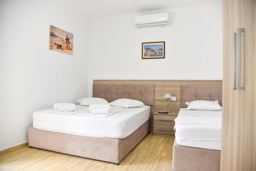 2 letti in una camera da letto con pareti bianche e pavimenti in legno di Vila Duro a Golem