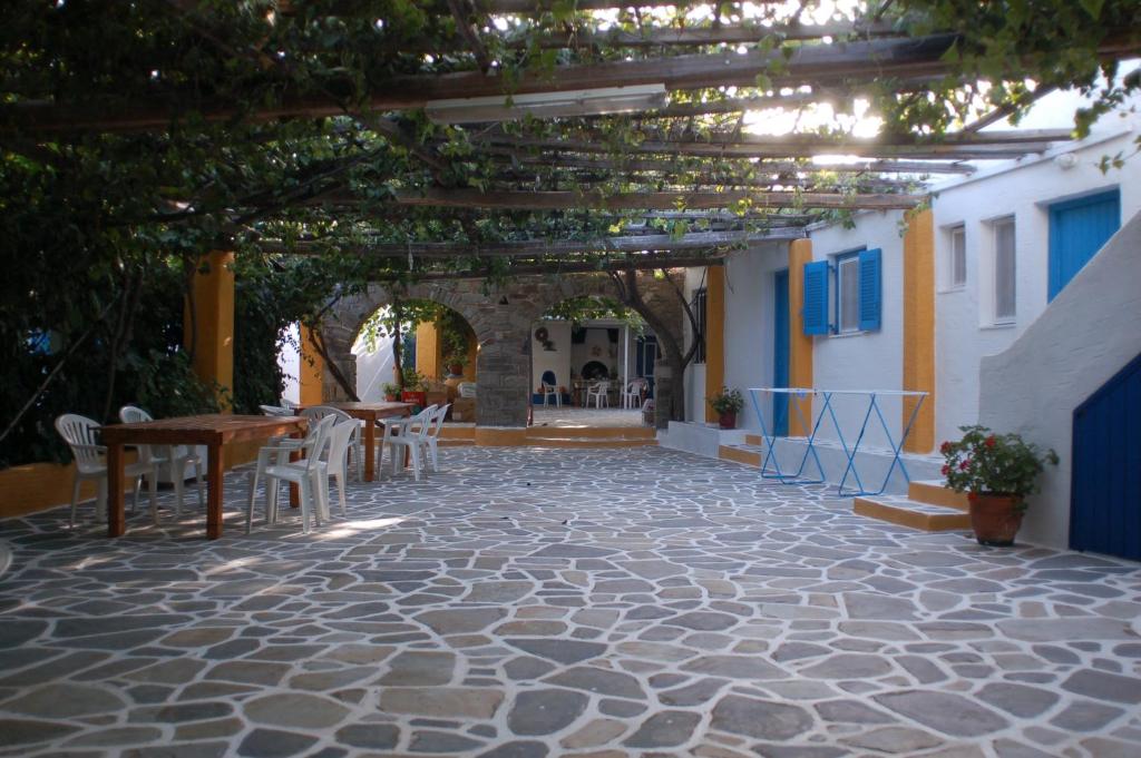 un patio con tavolo, sedie e arco di Miltiadis Apartments ad Ambelás