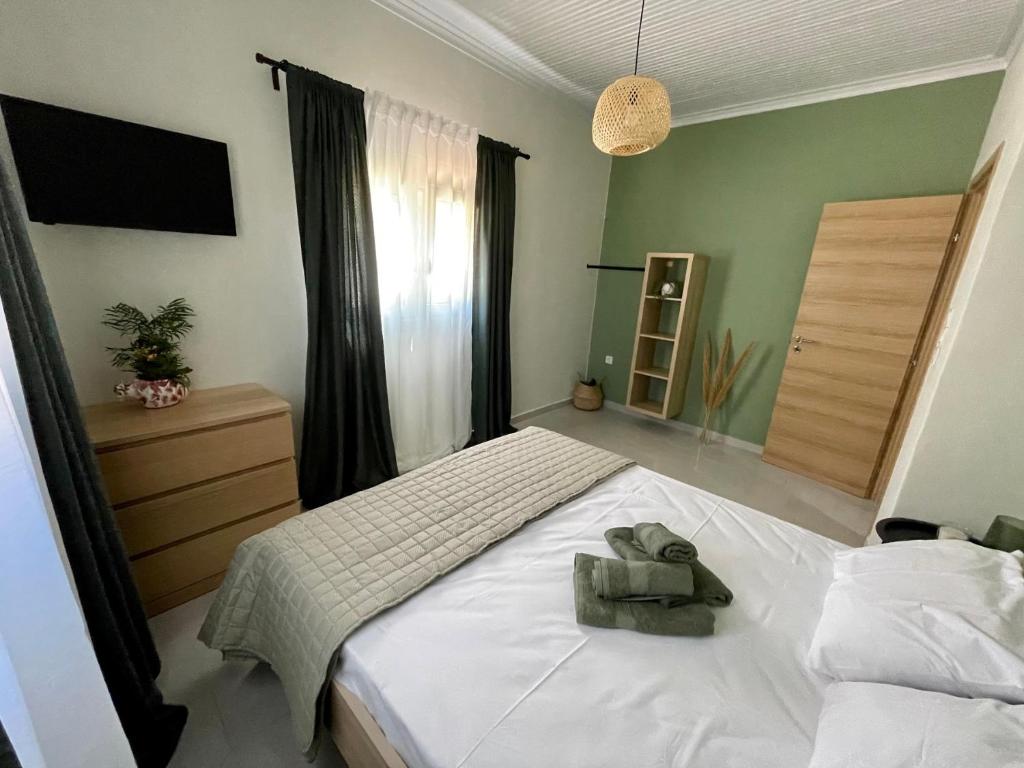 Un dormitorio con una cama blanca con una toalla. en Agrothi en Marathopoli