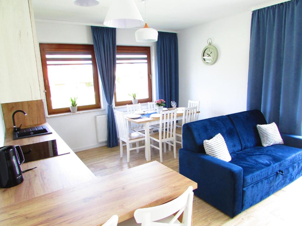Krajno-Zagórze的住宿－Agroturystyka Pod Szczytem，客厅配有蓝色的沙发和桌子