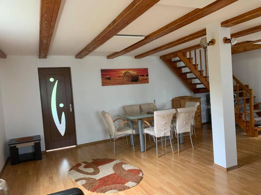 a dining room with a table and white chairs at Casa ANA in Geoagiu