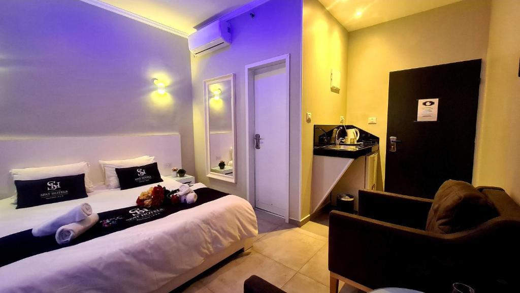 ein Hotelzimmer mit einem Bett und einem Stuhl in der Unterkunft Spat Hotel Ashdod in Aschdod