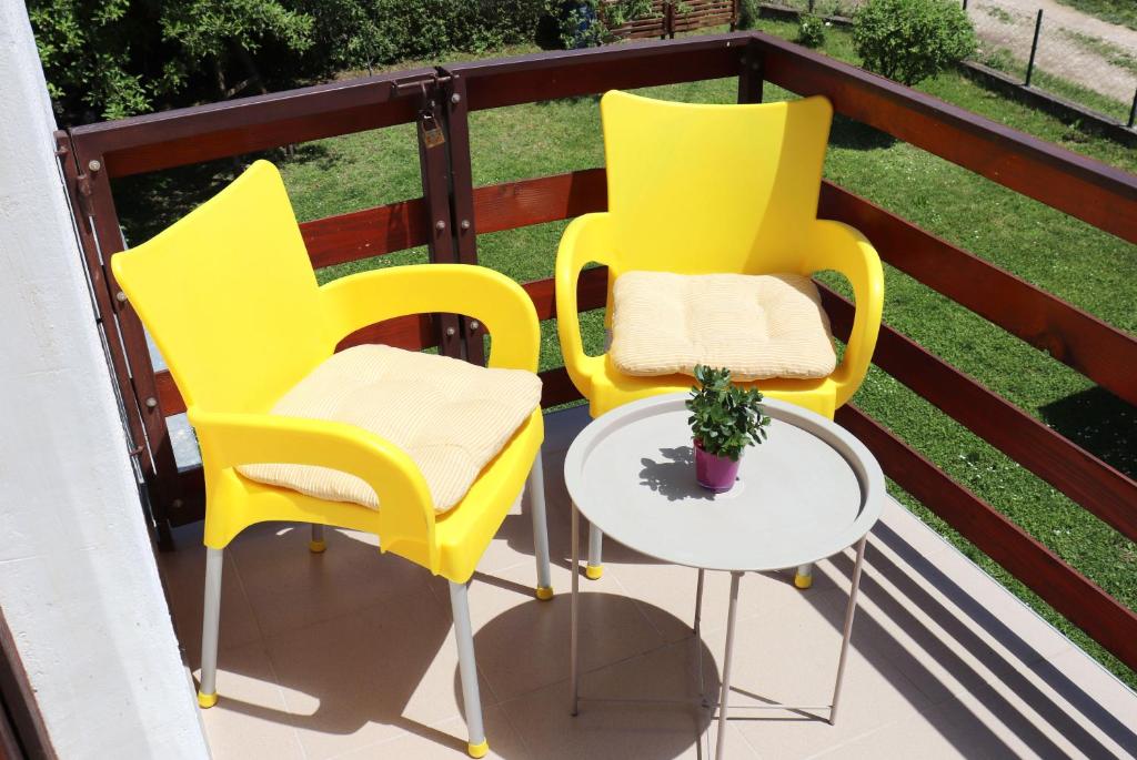 two yellow chairs and a table on a balcony at Zeleno srce in Soko Banja