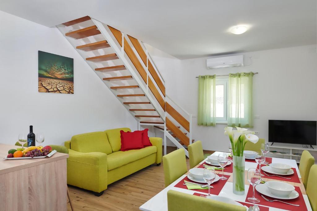 普拉的住宿－Apartment Olivix，客厅配有桌子和黄色椅子
