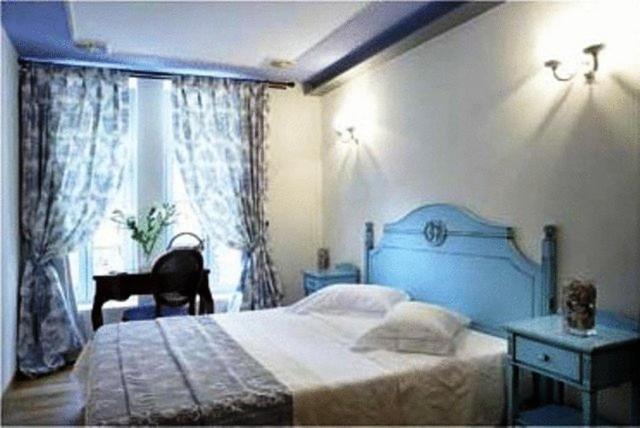 Un dormitorio con una cama azul y una ventana en Arhontiko Pepos en Nafpaktos