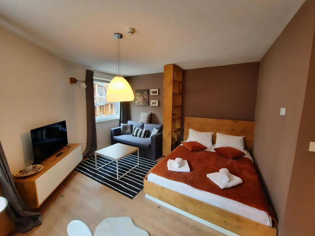 una camera da letto con un letto e un soggiorno di Mountain Angel Apartment a Jahorina