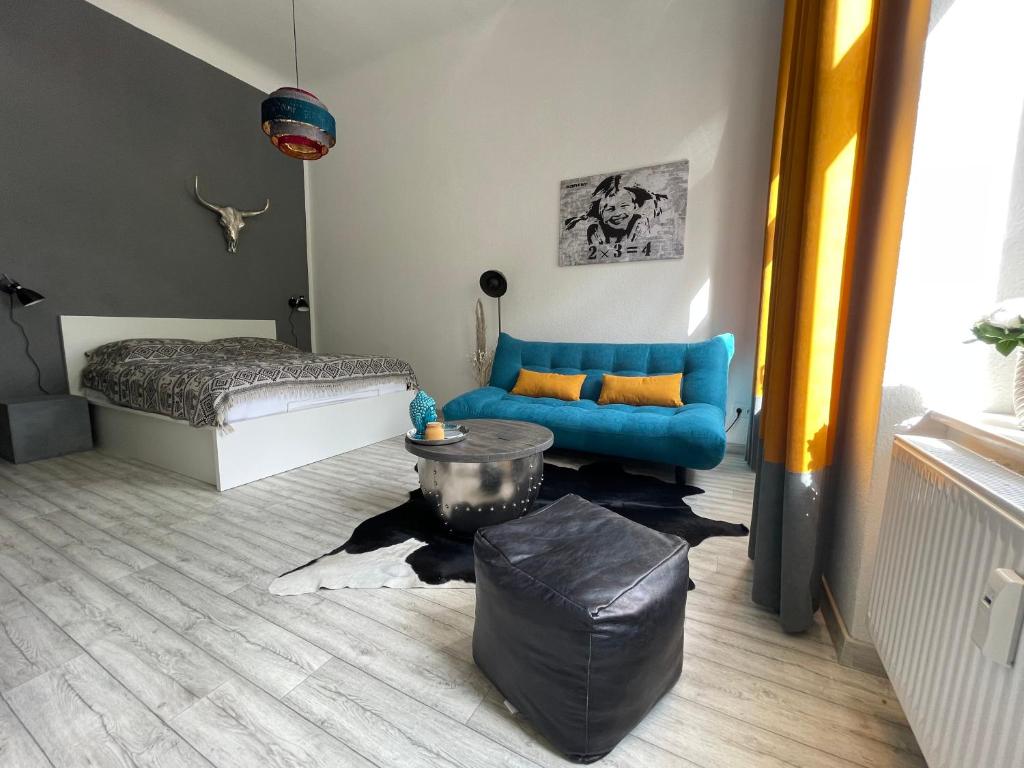 ein Wohnzimmer mit einem blauen Sofa und einem Bett in der Unterkunft DESIGN Apartment II - 45qm Grenze Altstadt Park in Görlitz