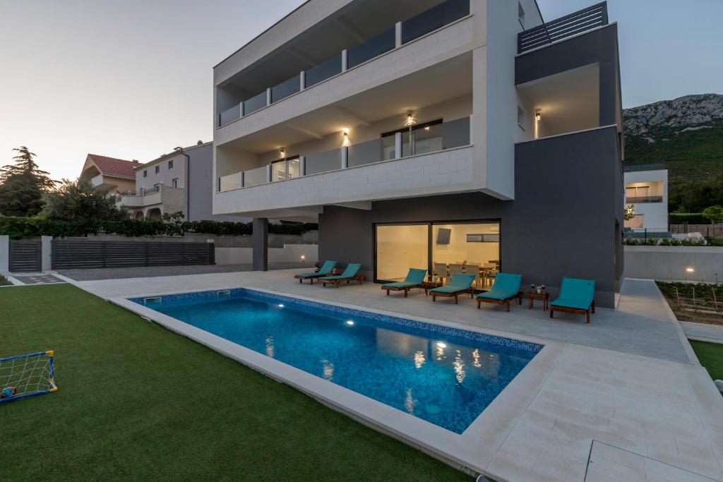 een huis met een zwembad in de achtertuin bij Luxury Villa La nonna Ana - heated pool, sea view, near Split in Kaštela