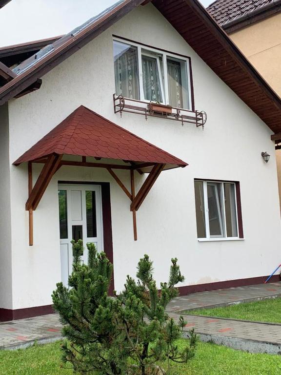 a white house with a red roof at LIKE HOME in Râşnov