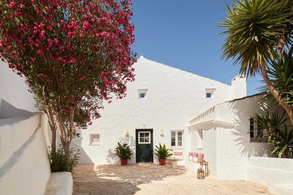 a white house with pink flowers in front of it at Agroturismo Rafal Rubí in Alaior