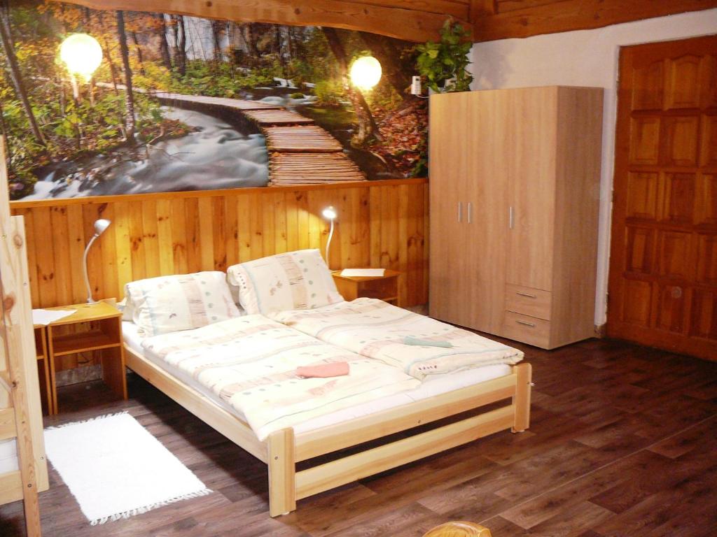 łóżko w pokoju z obrazem na ścianie w obiekcie Chatka Horec w Starej Leśnej