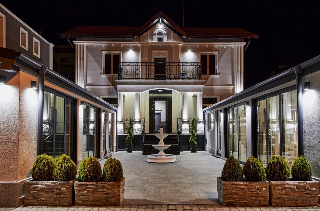 a large house with a courtyard at night at Хотел Паризи in Kazanlŭk