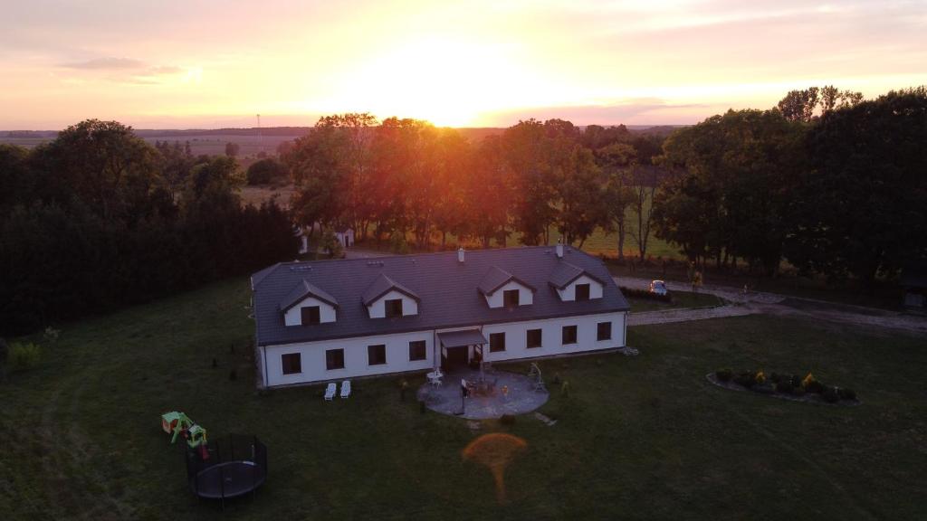 una vista aerea di una casa bianca con il tramonto sullo sfondo di Kantonia a Bobolice