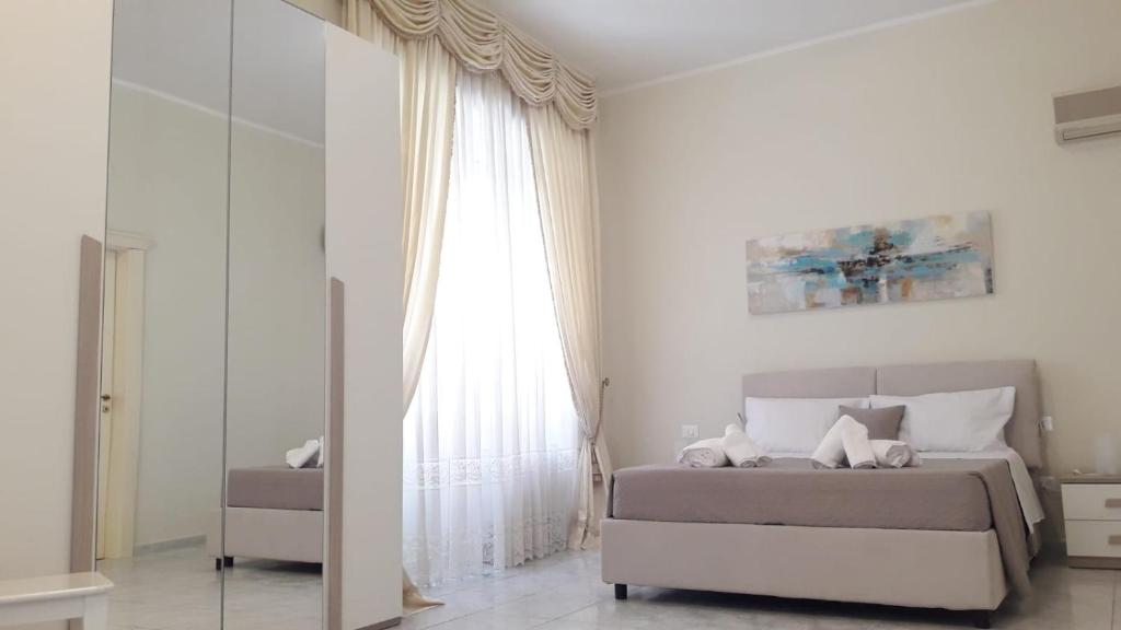 - une chambre avec un lit et une grande fenêtre dans l'établissement Sweet Home Agropoli, à Agropoli