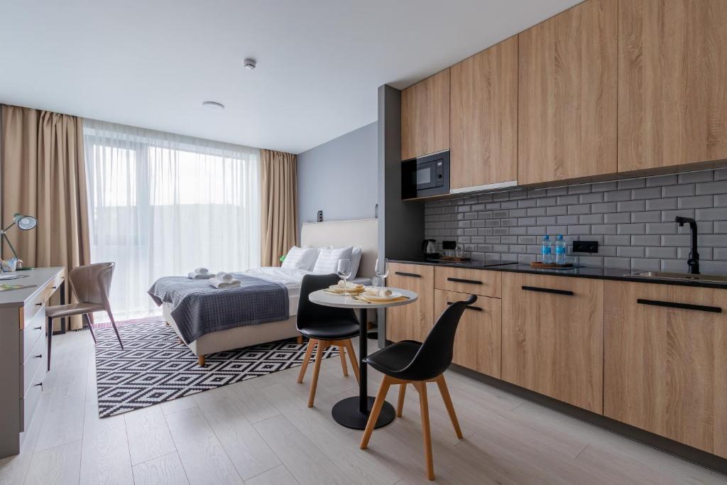 a kitchen and a bedroom with a bed and a table at Geleon Apart in Saint Petersburg