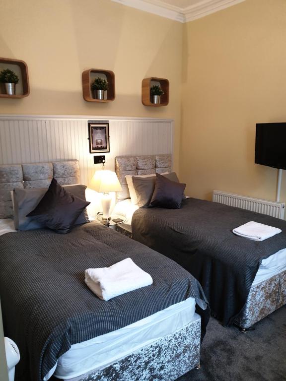 twee bedden naast elkaar in een kamer bij Frederick Douglass - Rooms In The City in Edinburgh