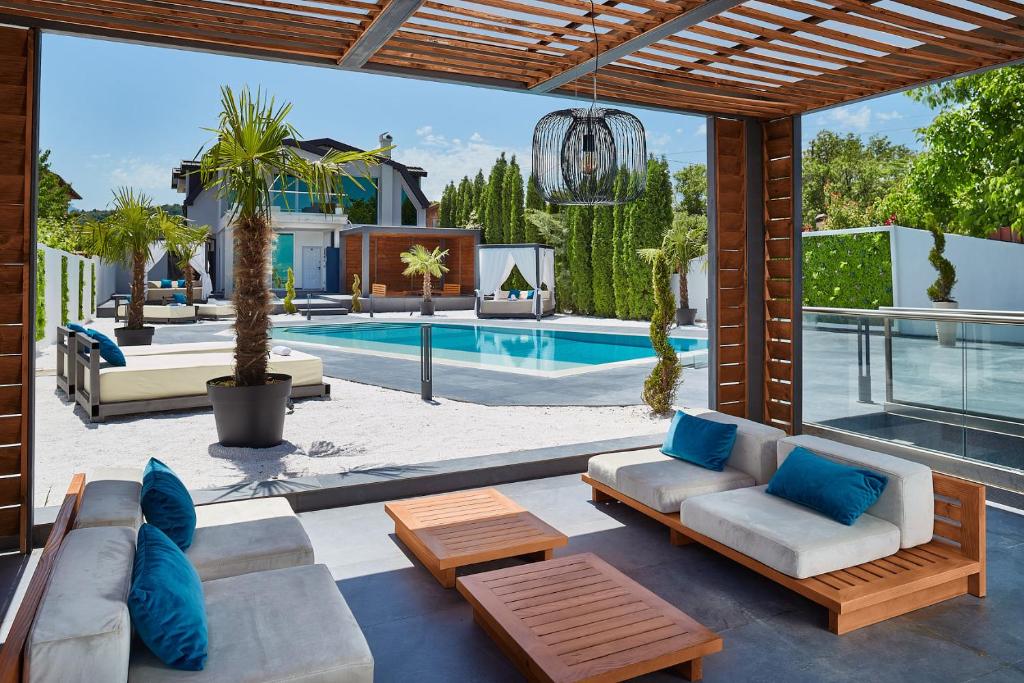 a patio with a couch and a swimming pool at Villa Lumiere in Skopje