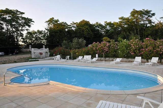 a swimming pool with chairs and a group at Bungalow Leo (123-11) in Savudrija