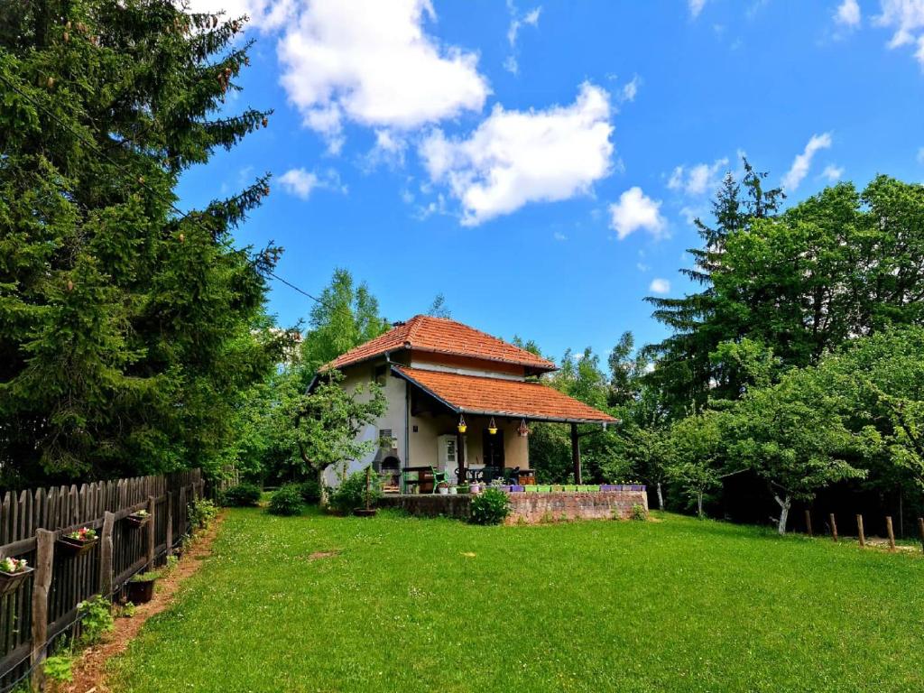 una pequeña casa en un patio con una valla en Holiday Home Čarobna Kućica en Pale