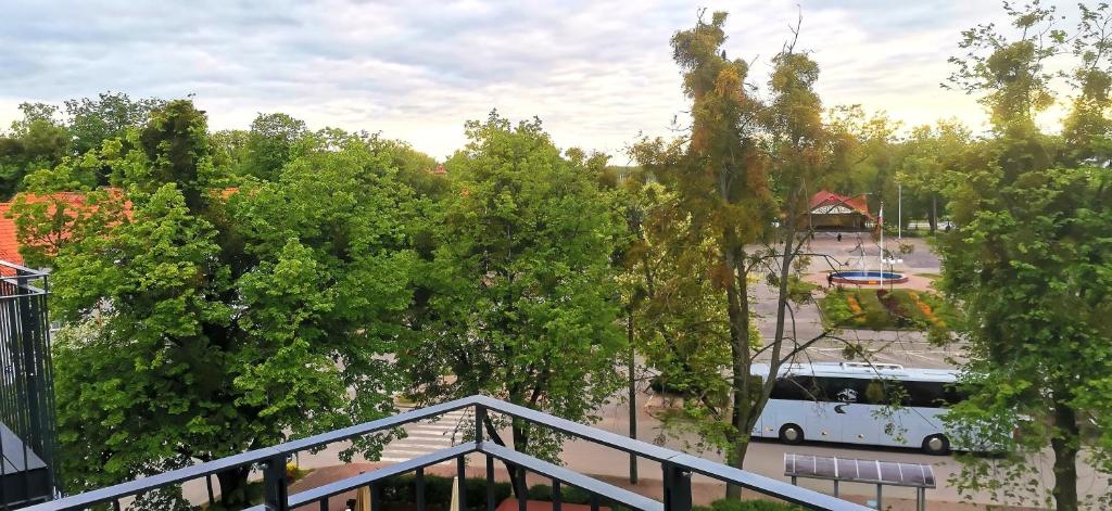 Biały autobus stoi na parkingu w obiekcie Apartamenty Green&Blue w Węgorzewie- GREEN w Węgorzewie