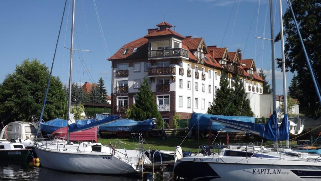 grupa łodzi zacumowanych przed dużym budynkiem w obiekcie Prywatne apartamenty z widokiem na Port lub Zamek Krzyżacki w Węgorzewie