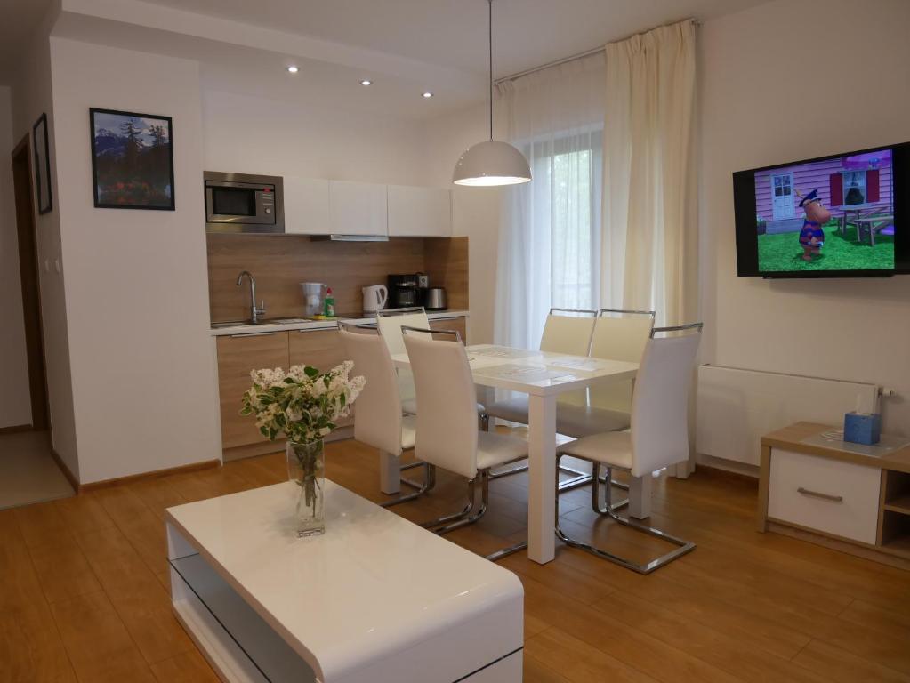 cocina y comedor con mesa blanca y sillas en Apartament Mondi Kai I - idealny na pobyt w górach, en Szklarska Poręba