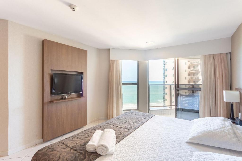 - une chambre avec un lit, une télévision et un balcon dans l'établissement Beach Class Prestige Boa Viagem, à Récife