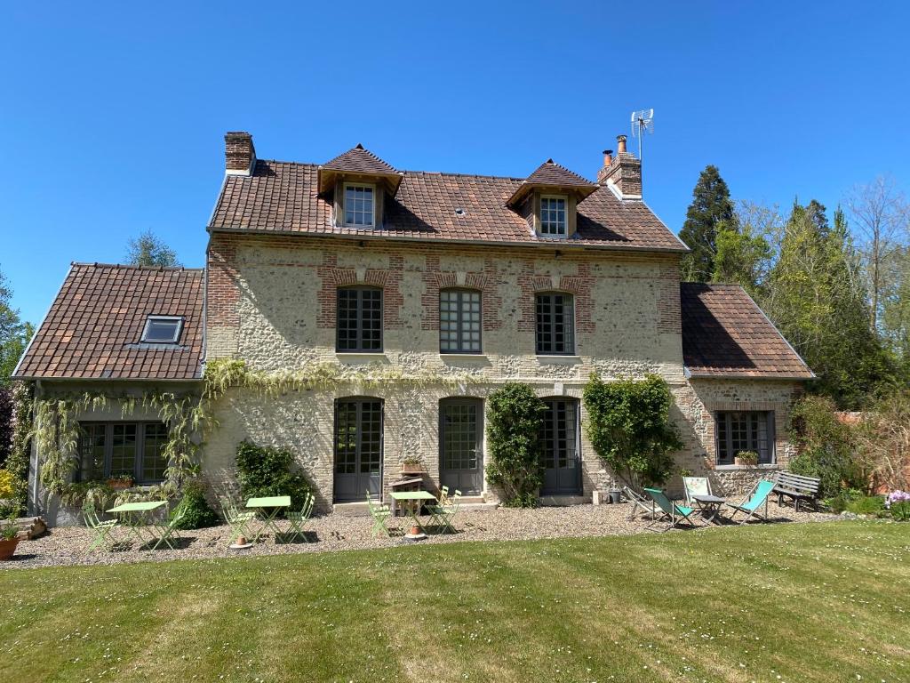 una antigua casa de piedra con un gran patio en La Maison d'Aline - Honfleur - Maison d'Hôte De Charme A La Normande, en Honfleur
