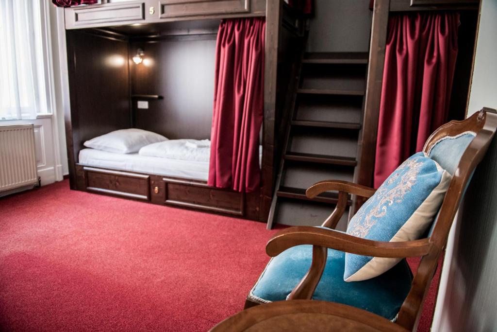 Zimmer mit einem Etagenbett, einem Stuhl und einer Treppe in der Unterkunft Vienna Boutique - Premium Hostel in Wien